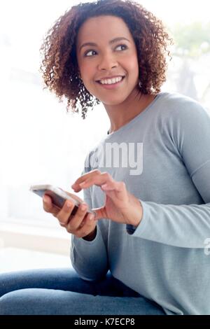 Mitte der erwachsenen Frau mit Handy. Stockfoto