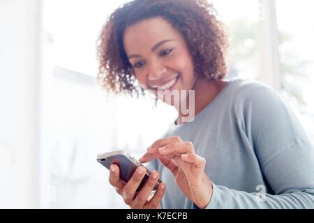 Mitte der erwachsenen Frau mit Handy. Stockfoto