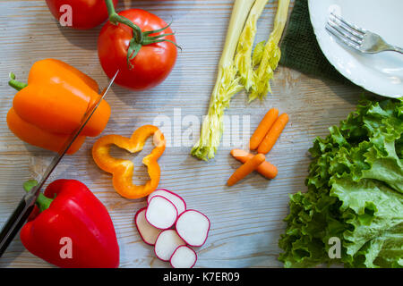 Flach salat Zutaten auf rustikalen hölzernen Brettern und mit der Gabel Schüssel und Kochmesser. Stockfoto