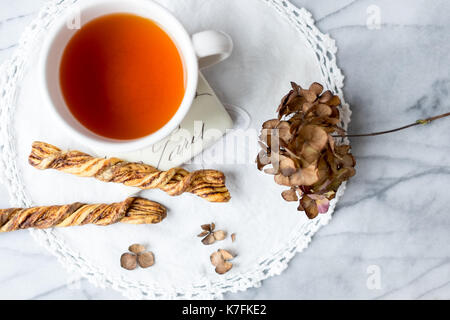 Tasse Kaffee und Zimt twist Cookies auf dem Marmortisch. Paris coaster. Ansicht von oben. Stockfoto