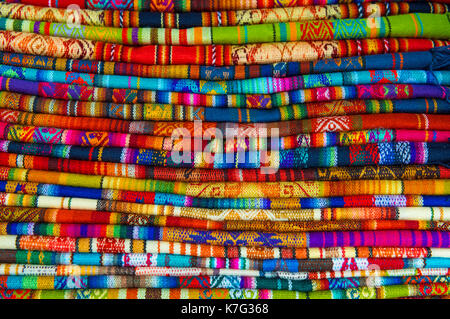 Ein Haufen von bunten Anden Textilien in das örtliche Handwerk Markt von Cusco, Peru fotografiert. Stockfoto