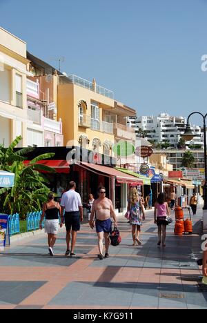 Touristen zu Fuß entlang der Promenade mit Geschäften und Restaurants auf der linken Seite, Torremolinos, Provinz Malaga, Andalusien, Spanien, Westeuropa Stockfoto