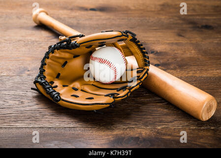 Close-up Leder Handschuh mit Baseball und Fledermaus auf hölzernen Tisch Stockfoto