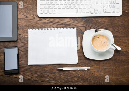 Hohe Betrachtungswinkel der Digitalen Tablet mit Tagebuch und Tasse Tee auf Schreibtisch Stockfoto