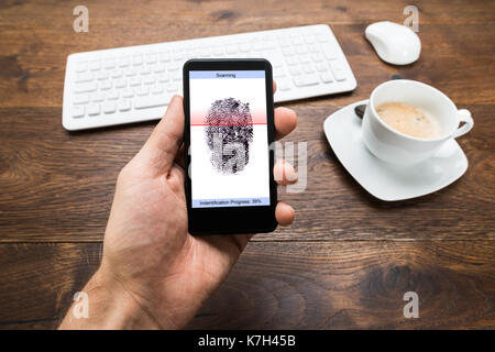 Nahaufnahme der Person Hände mit Handy Übersicht Anwendung zum Scannen von Fingerabdrücken Stockfoto