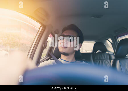 Asiatische Thai chinesische Mann männliche ware Schwarze Sonne Glas Auto fahren in heissen Sommertag. Stockfoto