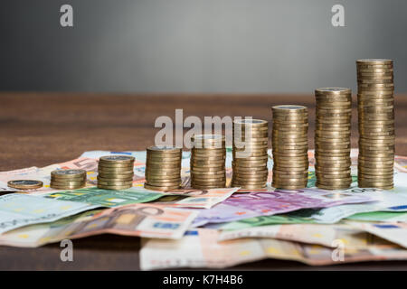 Nahaufnahme einer Gestapelte Münzen arrangiert auf Euro-banknoten Stockfoto