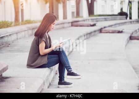 Asian teen Frauen lesen Buch Glück und Lächeln Ausbildung in Universität genießen. Stockfoto