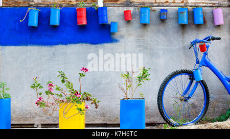 Dekoration Wand im griechischen Stil mit Blume und alten verrosteten Fahrrad. Stockfoto