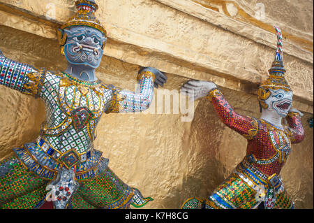 Mythische Dämonenwächter um die Basis eines der zwei Goldenen Cheden am Tempel des Smaragdbuddhas. Der Große Palast, Bangkok, Thailand Stockfoto