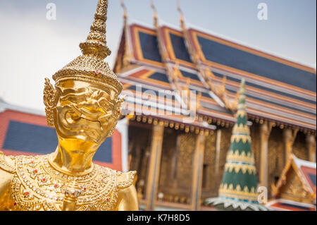 Mythische Dämonenschutzstatue vor dem Hintergrund von Phra Ubosot (der Kapelle des Smaragdbuddhas) im Wat Phra Kaew. Der Große Palast, Thailand Stockfoto