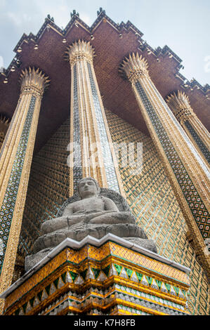 Buddha-Statue außerhalb Phra Mondop (Bibliothek) im Wat Phra Kaew (Tempel des Smaragd-Buddha). Der Große Palast, Bangkok, Thailand Stockfoto