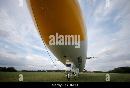 Neumünster, Deutschland. 15 Sep, 2017. Eine 75 Meter lange Zeppelin landet in Neumünster, Deutschland, 15. September 2017. Das luftschiff wirbt für ein baumaschinenhersteller mit dem gleichen Namen auf einer Messe, die sich in der Stadt an der gleichen Zeit braucht. Foto: Markus Scholz/dpa/Alamy leben Nachrichten Stockfoto