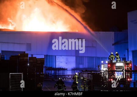 Plettenberg, Deutschland. 15 Sep, 2017. Feuerwehrleute Löschen eines Brandes in einem Werk von einem Zulieferer der Automobilindustrie in Plettenberg, Deutschland, 15. September 2017. Elf Menschen wurden bei dem Brand am Freitag Nacht verletzt. Das Rettungsteam den Bereich des Feuers evakuiert sowie benachbarten Wohnungen aufgrund von möglicherweise gefährlichen Chemikalien. Foto: Markus Klümper/dpa/Alamy leben Nachrichten Stockfoto