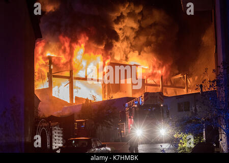 Plettenberg, Deutschland. 15 Sep, 2017. Ein feuerwehrauto stand vor der brennenden Fabrik von einem Zulieferer der Automobilindustrie in Plettenberg, Deutschland, 15. September 2017. Elf Menschen wurden bei dem Brand am Freitag Nacht verletzt. Das Rettungsteam den Bereich des Feuers evakuiert sowie benachbarten Wohnungen aufgrund von möglicherweise gefährlichen Chemikalien. Foto: Markus Klümper/dpa/Alamy leben Nachrichten Stockfoto