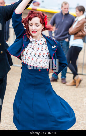 Junge Paare tanzen in 1950s Kleidung. Frau im blauen Rock und Jacke, Mann in Uniform der Royal Navy Officer, während der Gruß an die 40 das beliebte Wochenende im Chatham Historic Dockyard. Stockfoto