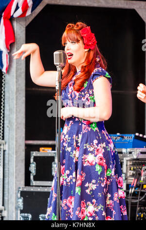 England, Chatham Dockyard. Veranstaltung, Gruß zu den 40er Jahren. Eine der Polka Dot Puppen, einen Vocal Harmony-Typ Trio, auf der Bühne zu singen, während vor dem Mikrofon. Stockfoto