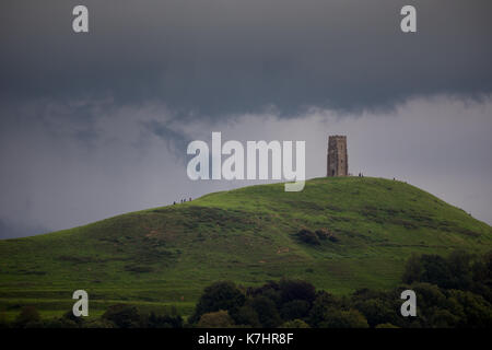 16. September 2017, Glastonbury, Somerset. Nach einem schönen, aber kalten Tag in Glastonbury den Himmel entwickelte sich schnell zu einem Gewitter über dem berühmten St. Michaels Turm auf dem Tor. Die Menschen weiterhin die Spitze der Hügel zu erkunden trotz Blitze und Grollen des Donners. Schwere nach unten strömt über den alten Landschaft, wodurch lokalisierte Hochwasser mitgerissen. Credit: Wayne Farrell/Alamy leben Nachrichten Stockfoto