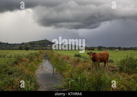 16. September 2017, Glastonbury, Somerset. Nach einem schönen, aber kalten Tag in Glastonbury den Himmel entwickelte sich schnell zu einem Gewitter über dem berühmten St. Michaels Turm auf dem Tor. Die Menschen weiterhin die Spitze der Hügel zu erkunden trotz Blitze und Grollen des Donners. Schwere nach unten strömt über den alten Landschaft, wodurch lokalisierte Hochwasser mitgerissen. Credit: Wayne Farrell/Alamy leben Nachrichten Stockfoto