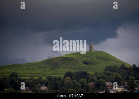 16. September 2017, Glastonbury, Somerset. Nach einem schönen, aber kalten Tag in Glastonbury den Himmel entwickelte sich schnell zu einem Gewitter über dem berühmten St. Michaels Turm auf dem Tor. Die Menschen weiterhin die Spitze der Hügel zu erkunden trotz Blitze und Grollen des Donners. Schwere nach unten strömt über den alten Landschaft, wodurch lokalisierte Hochwasser mitgerissen. Credit: Wayne Farrell/Alamy leben Nachrichten Stockfoto