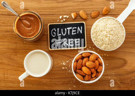 Glutenfreie Lebensmittel aus Mandeln mit Mandelmilch Mehl und Butter auf Holztisch, Ansicht von oben Stockfoto
