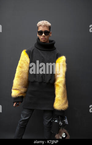 LONDON, ENGLAND - 15. September 2017 Eine junge Kurzhaarigen blonden Mann in einem schwarzen Pullover mit gelben Ärmel aus Fellimitat während der London F posing Stockfoto