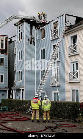 Feuerwehrmänner, die bleiben in der Szene nach einem großen Feuer in einem Mehrfamilienhaus in Snodland, Kent. Stockfoto