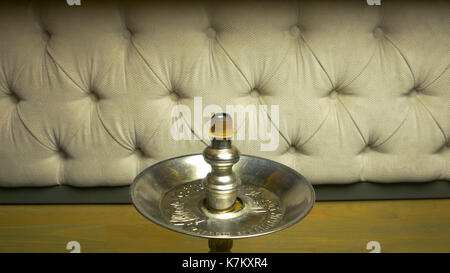 Rauch Shisha auf einem schwarzen Hintergrund mit einem schönen Rauch. Braun shisha Schüssel für Tabak mit langem Bein. Vorbereiten der Shisha, nargile Shisha aka oder in einem Restaurant, indem Sie den Holzkohlen auf der Oberseite. Stockfoto