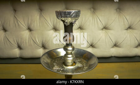 Rauch Shisha auf einem schwarzen Hintergrund mit einem schönen Rauch. Braun shisha Schüssel für Tabak mit langem Bein. Vorbereiten der Shisha, nargile Shisha aka oder in einem Restaurant, indem Sie den Holzkohlen auf der Oberseite. Stockfoto