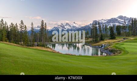 Golfplatz Green Grass Meadow Wunderschöne Malerische Landschaft Blick Auf Drei Schwestern Snowy Mountain Peak. Canmore Town, Alberta Foothills Canada Rockies Stockfoto