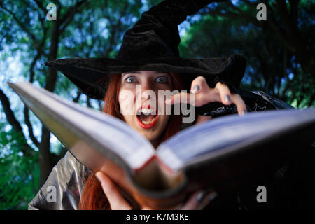 Close-up-Bild der Hexe Lesen Rechtschreibprüfung aus Buch am Wald Stockfoto