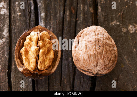 Die beiden Muttern, eine offene und eine auf einen alten Holztisch geschlossen Stockfoto