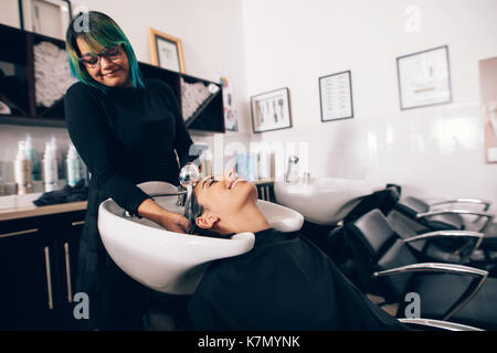 Weibliche Friseur Haar spülen eines Kunden. Friseur Haar waschen an den Kunden, bevor Sie Frisur Stockfoto