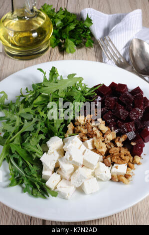 Die Zutaten für die Zubereitung von Salat aus gerösteten Rüben, Rucola, Käse Feta, und Walnüsse. Vertikale erschossen. Blick von oben. Stockfoto