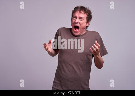 Ein Mann mittleren Alters stehen und schreien Stockfoto