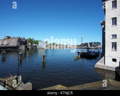 Dieses Foto zeigt das Oosterdok, ein Hafengebiet in Amsterdam, das aus dem Stadtteil Kattenburg stammt und die Wasserstraße, die modernen Gebäude und die städtische Entwicklung der Stadt zeigt. Stockfoto