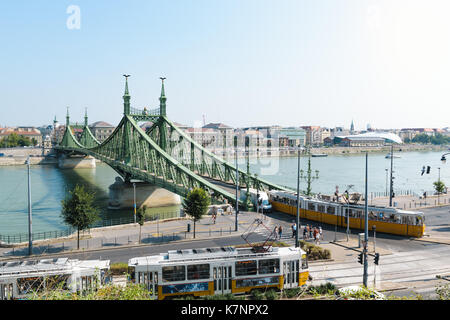 Die Brücke in Budapest, Ungarn mit einigen alten Straßenbahnen im Vordergrund vorbei. Stockfoto