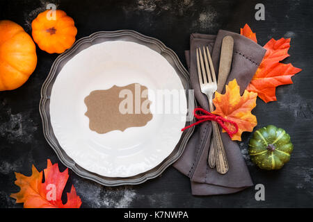 Happy Thanksgiving Tisch Einstellung mit Vintage Besteck mit herbstlichen Blätter und dekorative Kürbisse mit einer Platte am rustikalen Holzmöbeln ba eingerichtet Stockfoto