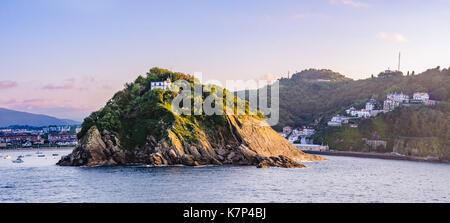 Blick auf eine Insel La Perla in San Sebastian, Spanien leuchtet durch Golden Sunset light Stockfoto