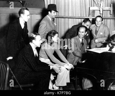 Auf dem Film set der Halle Wir Tanzen", George Gershwin am Klavier mit (L-R) Hermes Pan, Tanz Direktor; Fred Astaire; Mark Sandrich, Regisseur des Films; Ginger Rogers; Herr Gershwin; sein Bruder Ira Gershwin, und Nathaniel Shilkret, musikalischer Leiter, Hollywood, CA, 1936 fotografiert. Stockfoto