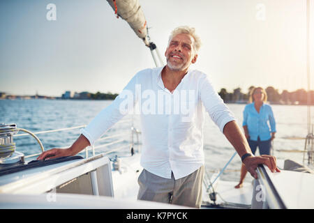 Reifes Paar stehen zusammen auf dem Deck Ihres Bootes genießen den Tag Segeln auf dem Ozean Stockfoto