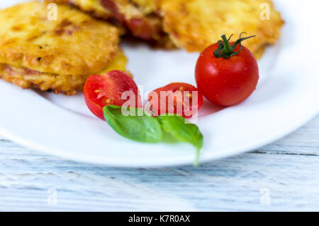 Koteletts und Cocktailtomaten. Teller auf eine weiße Platte. Stockfoto