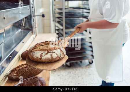 Frau in der Bäckerei, Brot an Bord Stockfoto