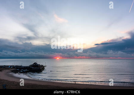 England, Broadstairs. Sonnenaufgang über dem Meer mit Broadstairs Hafen im Vordergrund. Dicke Wolken am Horizont, klaren Himmel oben. Stockfoto