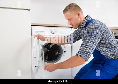 Junge männliche Techniker in der Festsetzung der Waschmaschine Stockfoto