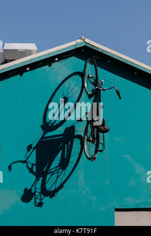 Das Fahrrad ist auf eine Seite eines Gebäudes in der Nähe des Hafens von Reykjavik montiert. Stockfoto