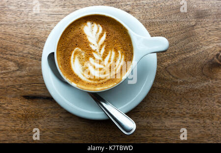 Caffè Latte Macchiato in einem weißen Schale auf einem Holztisch Stockfoto