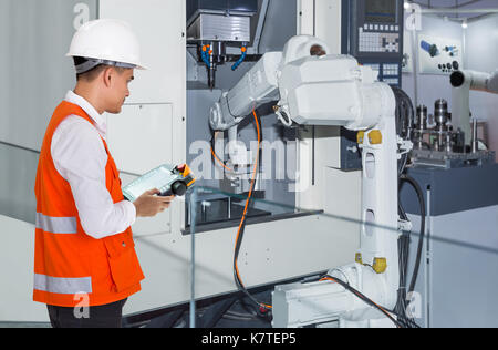 Ingenieur Steuerung von automatischen roboterhand Werkzeugmaschinen mit CNC-Maschine in der Automobilindustrie Stockfoto