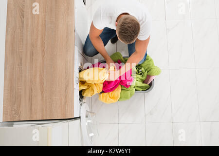 Hohe Betrachtungswinkel des jungen Mannes, Kleidung, Waschmaschine Stockfoto