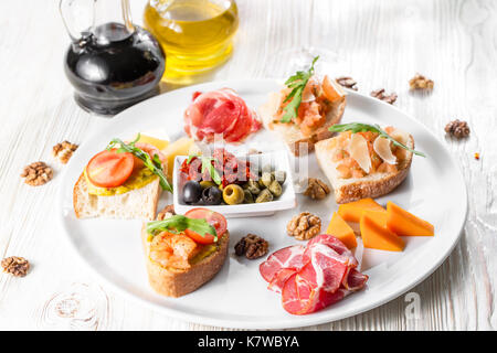 Auswahl an leckeren Bruschetta oder Häppchen auf taosted Baguette und Quark Käse garniert mit geräuchertem Lachs, Garnelen. Stockfoto